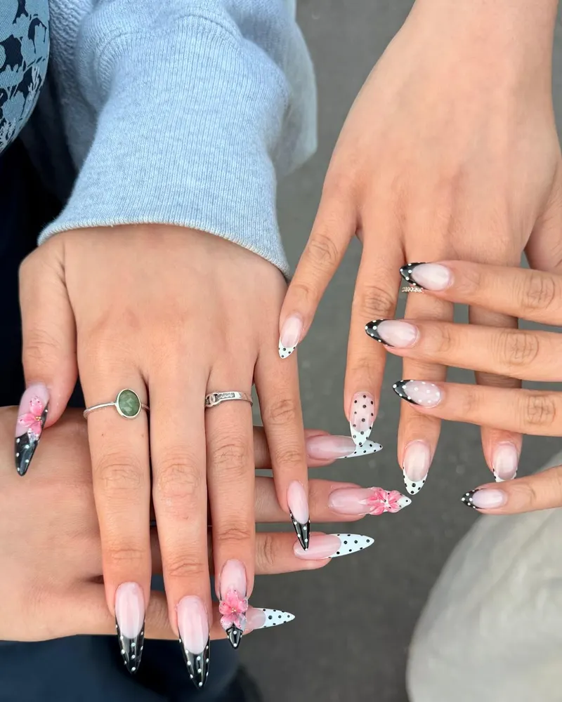Black polka dot French tips on two hands